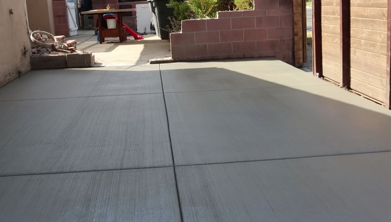 Freshly poured broom-finished concrete driveway with clean expansion joints installed in Harlingen, TX