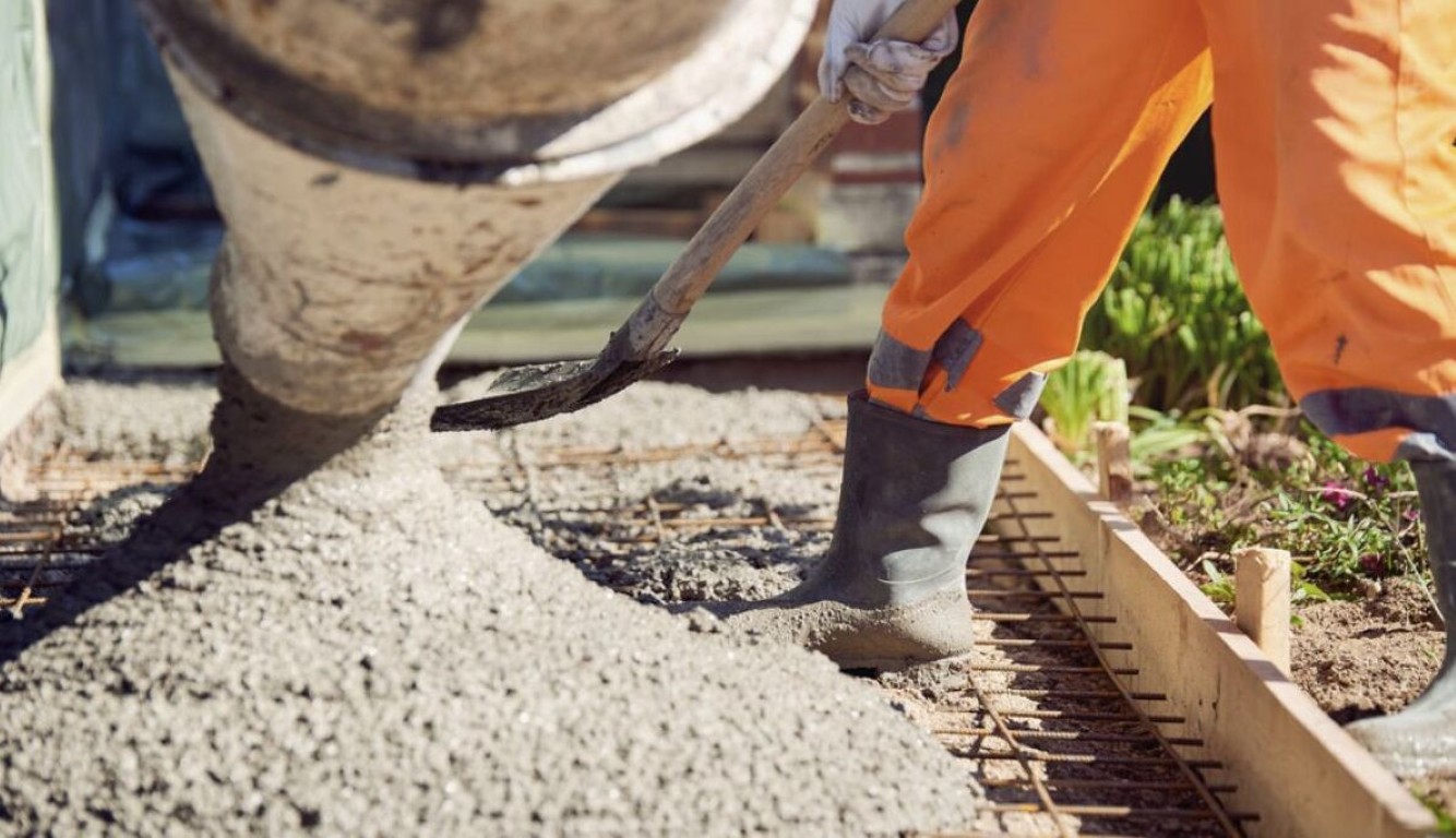 Concrete slab being poured over rebar reinforcement grid for a residential foundation in Harlingen, TX
